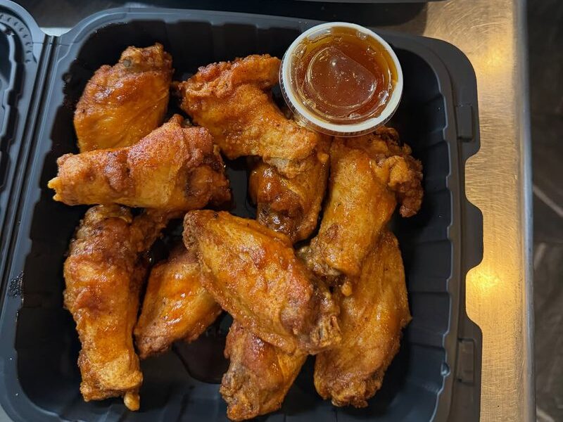 A tray of crispy bone-in wings with dipping sauce